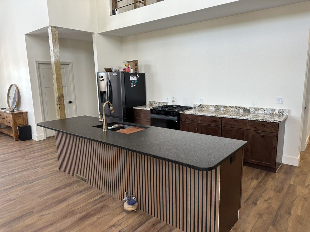 Leathered granite waterfall island — a real Precision Granite & Marble project near Elkins, AR.