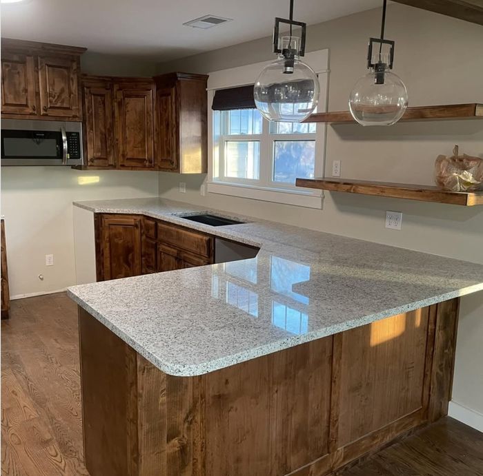 Speckled granite peninsula — a real Precision Granite & Marble customer photo.