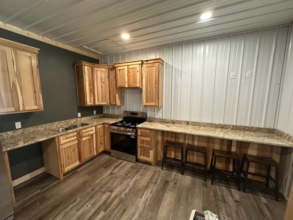 Granite countertops in a rustic barn-style kitchen with hickory cabinetry — a real Precision Granite & Marble project.