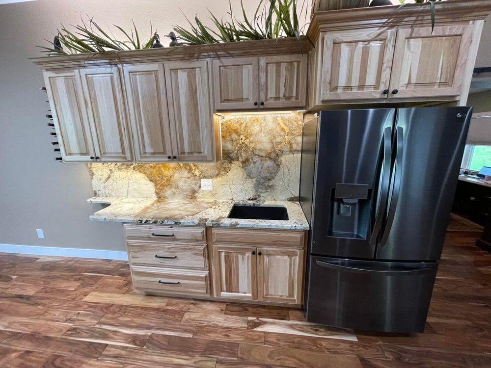 Backlit natural stone backsplash with dramatic gold veining — a real Precision Granite & Marble project.